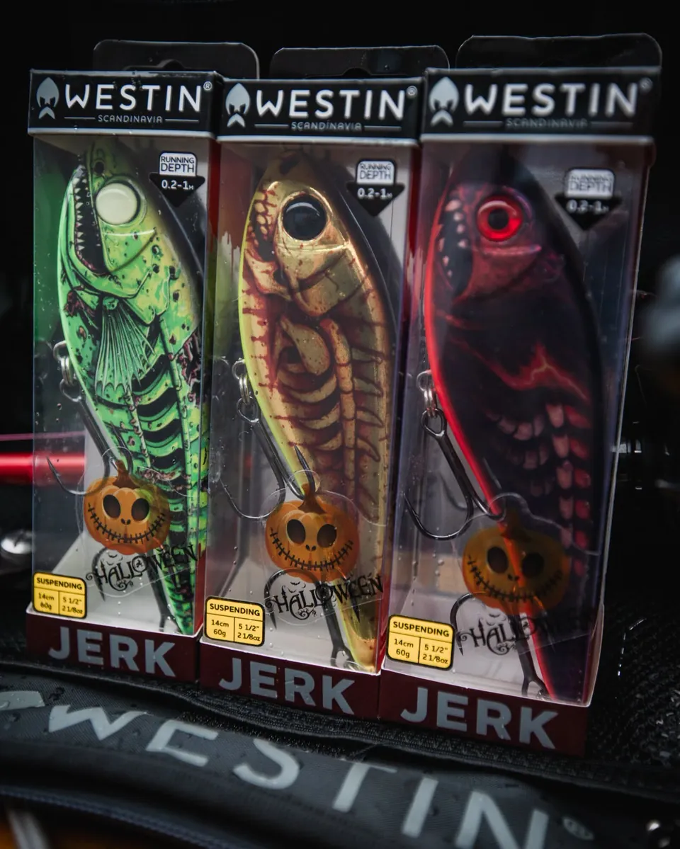 Trzy jerki Westin Jerk 14 cm 60 g suspending w halloweenowych kolorach w pudełkach: zielony z kośćmi, złoty z czerwonym szkieletem i ciemnoczerwony z czerwonym okiem